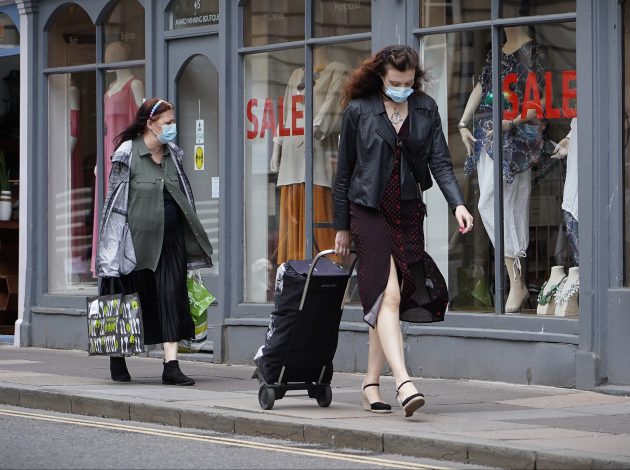 People walking through the streets of Bath wearing masks