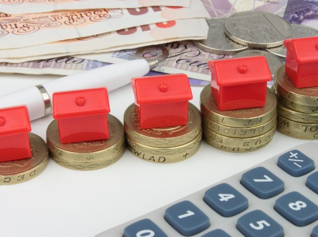 Monopoly type house pieces sat on top of pound coins