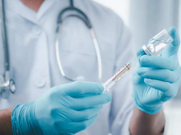 A medical professional prepares an injection