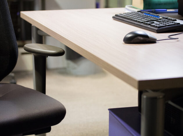 An image of an office type desk, there is a keyboard and mouse on it